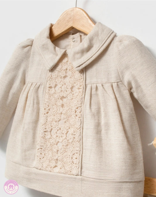 Close-up of baby girl lace blouse with delicate collar and refined details