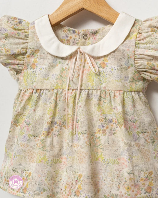 Close-up of floral girls summer blouse with puff sleeves and white collar