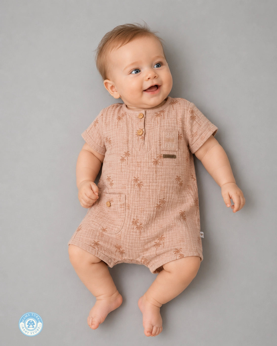 Baby wearing powder brown muslin romper with palm print by Mama Turka