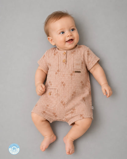 Baby wearing powder brown muslin romper with palm print by Mama Turka