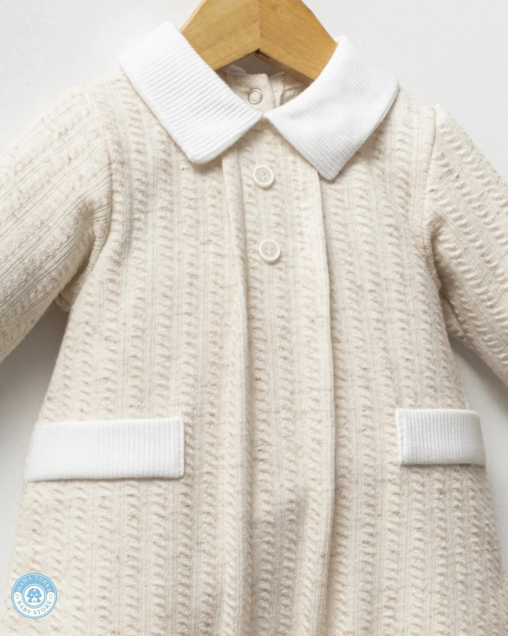 Close-up of baby boy romper with classic white collar, buttons and textured fabric