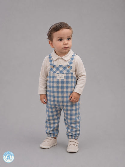 Baby boy wearing blue gingham overall set with cream shirt