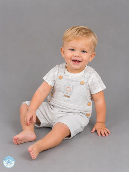 Baby boy wearing gray muslin romper set with T-shirt