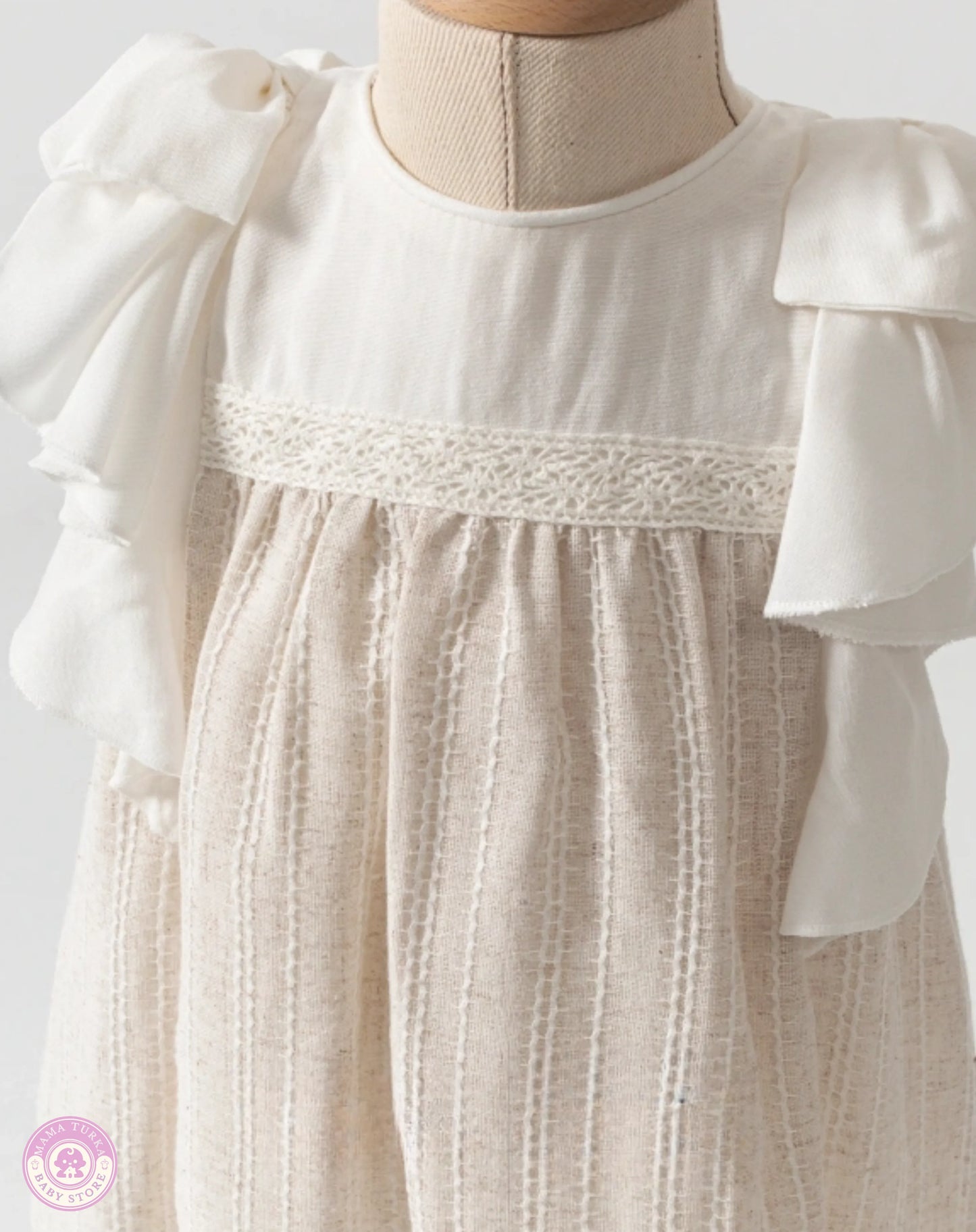 Close-up of baby girl ruffle dress with delicate lace details and soft natural fabric