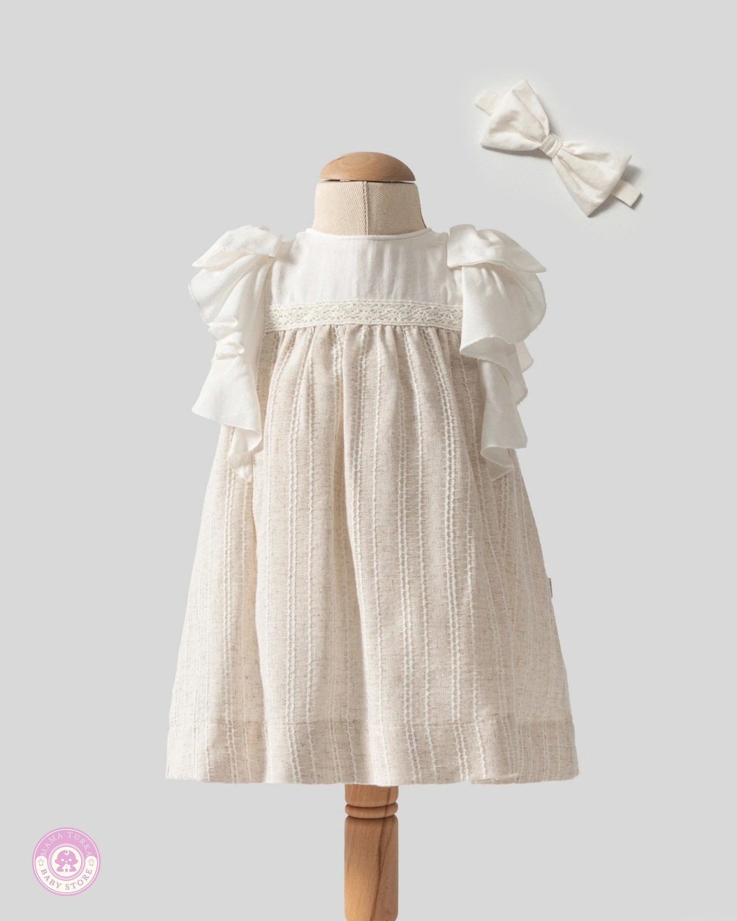 Elegant baby girl ruffle dress with lace details and matching hair bow by Mama Turka
