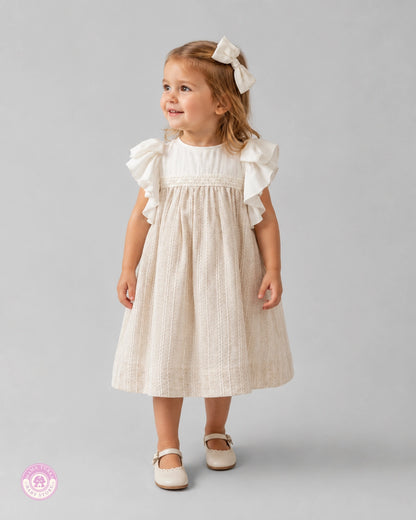 Baby girl wearing elegant ruffle dress with lace details and matching hair bow