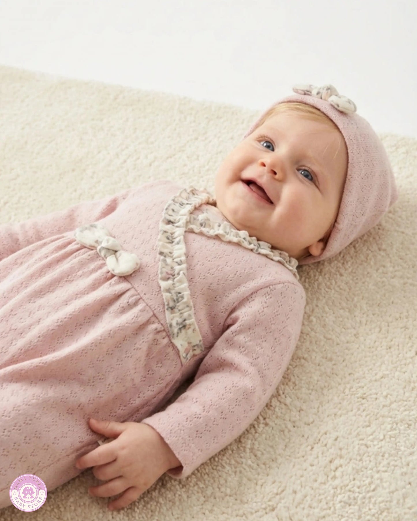 Baby wearing pink newborn girl set with matching hat and ruffle details