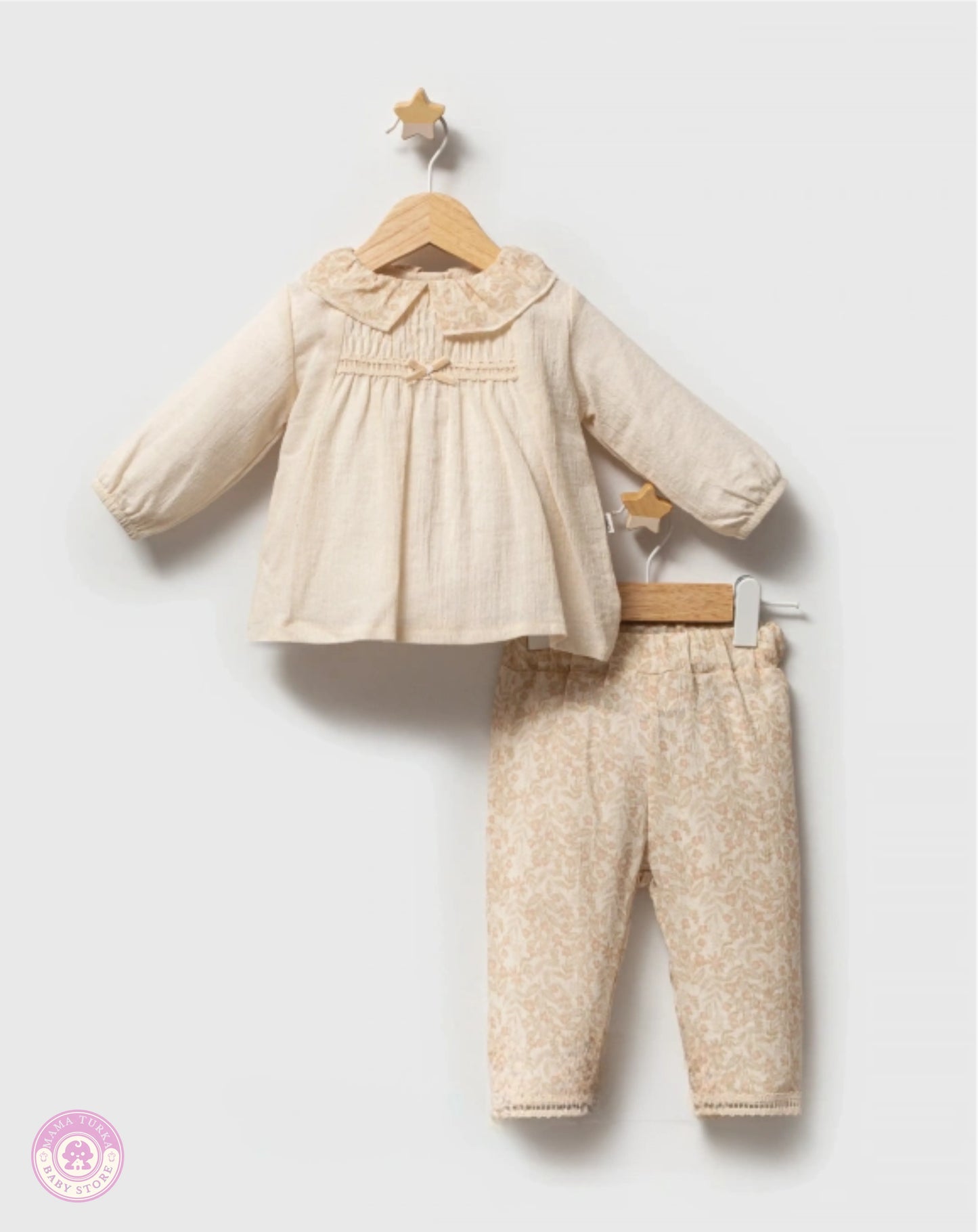 Cream baby girl outfit set with floral trousers on hanger