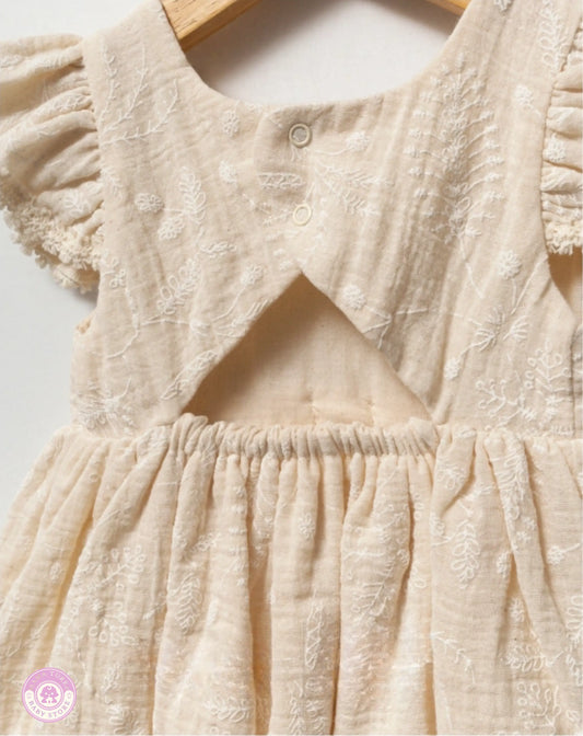 Close-up of girls cotton dress with bow, ruffled sleeves and embroidered details