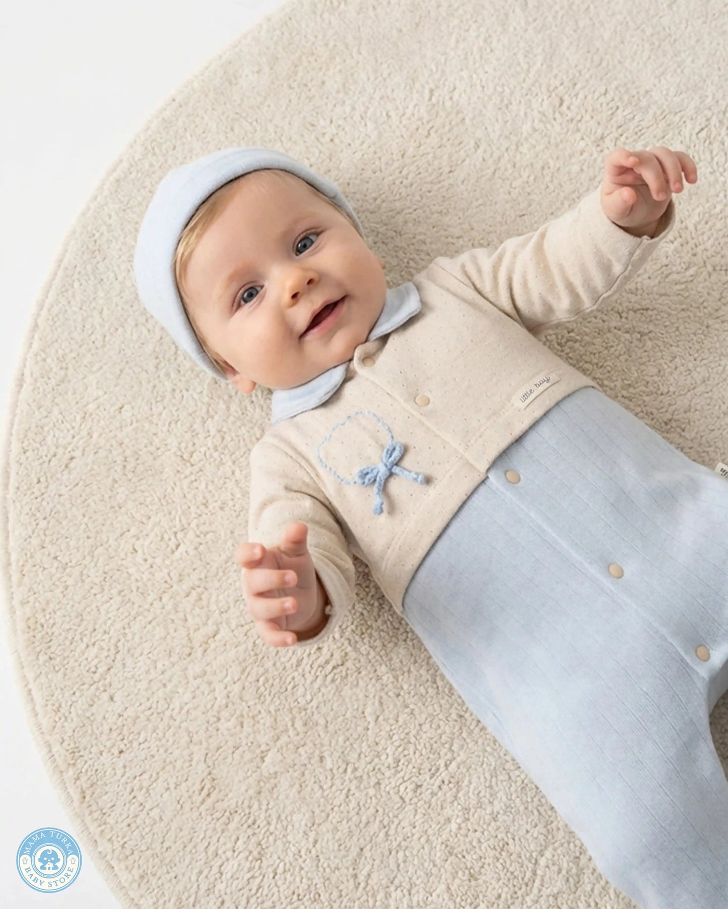 Newborn baby in soft blue cotton sleepsuit with delicate embroidery