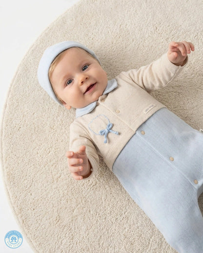 Newborn baby in soft blue cotton sleepsuit with delicate embroidery