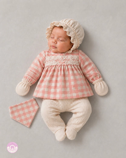 Newborn baby wearing pink gingham cotton set with bonnet and footed pants by Mama Turka