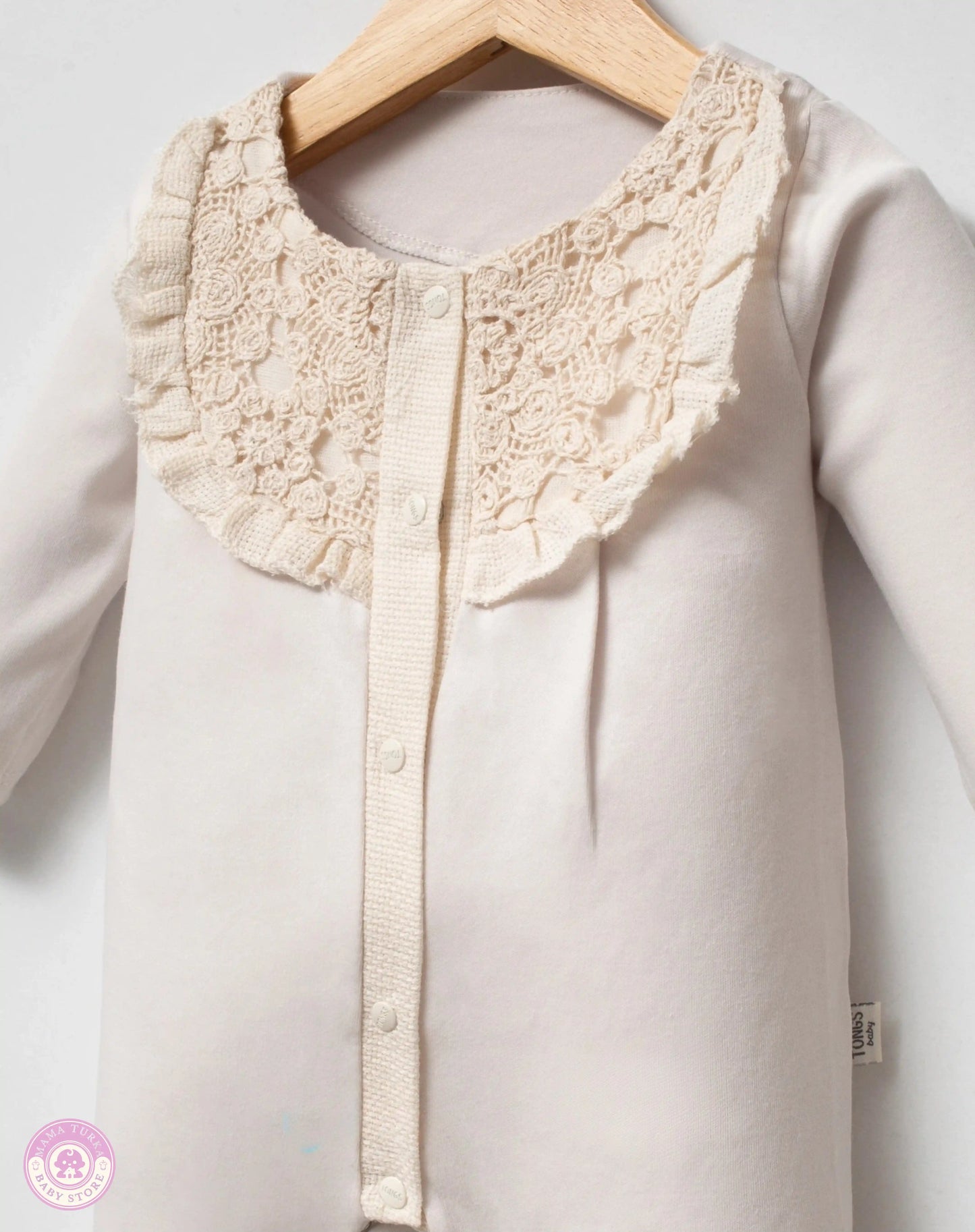 Close up of lace details on newborn baby outfit