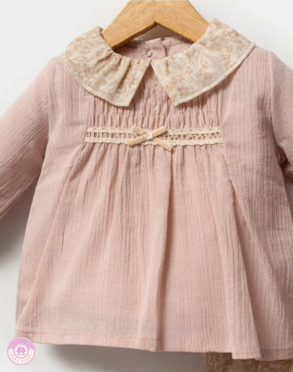 Close-up of pink cotton baby girl blouse with delicate floral collar