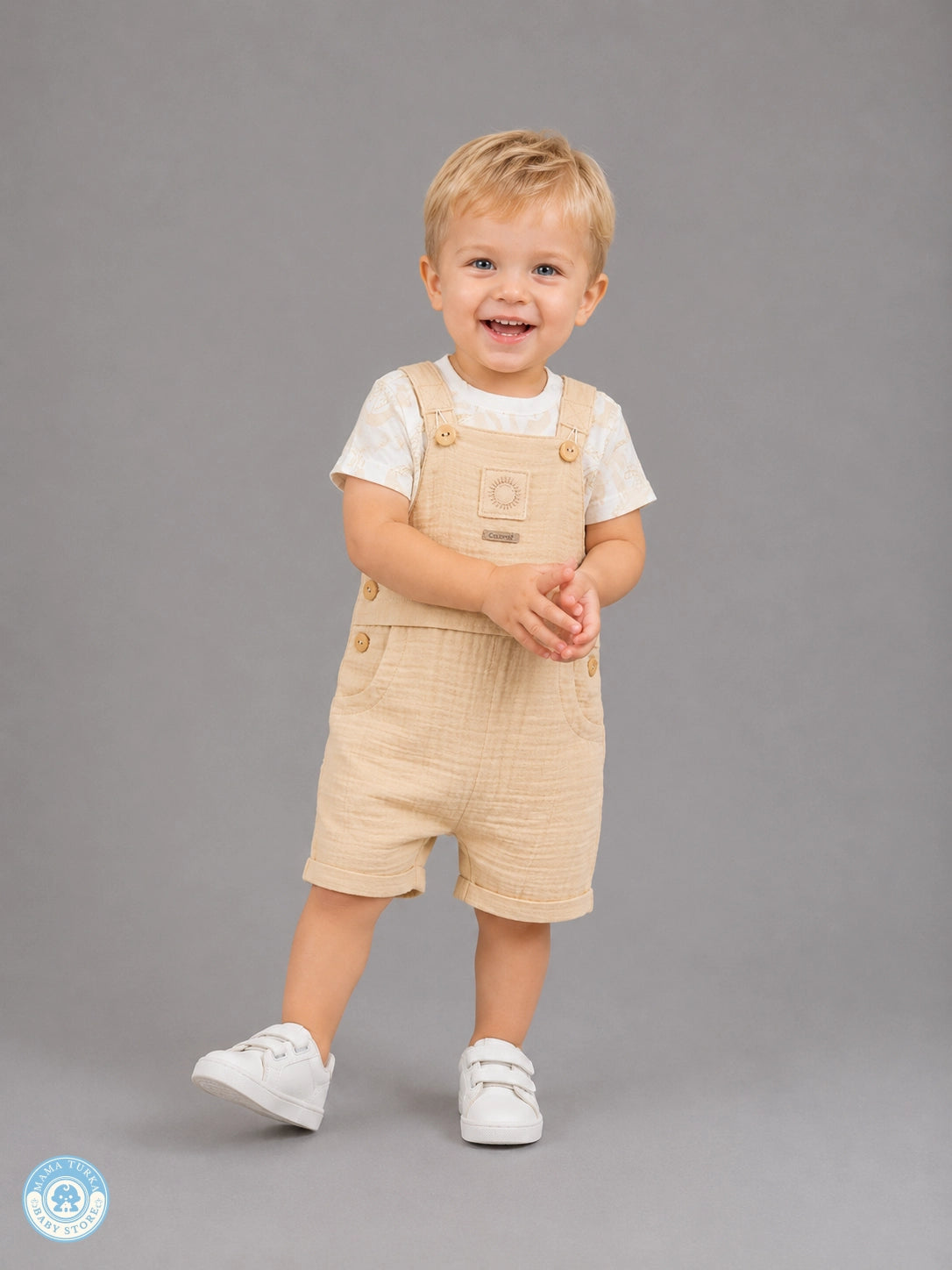 Toddler boy wearing sand muslin romper set with T-shirt
